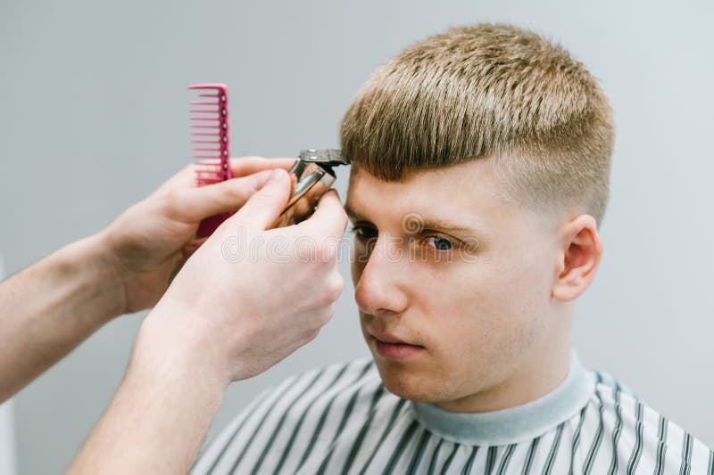 Portrait of a Young Man Cutting Hair in a Barber Shop with a Serious Face,close-up of a Hairdresser with a Trimmer Cut Client`s Stock Image - Image of care, haircut: 185496449 Portrait of a Young Man Cutting Hair in a Barber Shop with a Serious Face,close-up of a Hairdresser with a Trimmer Cut Client`s Stock Image - Image of care, haircut: 185496449