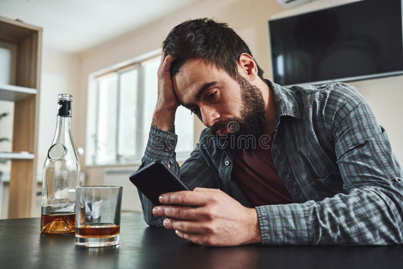 If you can quit for a day, you can quit for a lifetime. Young man alcoholic, social problems concept, sitting, drinking stock photography If you can quit for a day, you can quit for a lifetime. Young man alcoholic, social problems concept, sitting, drinking stock photography