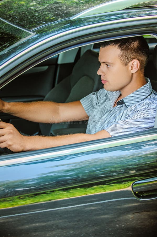 Portrait of young man driving car stock image Portrait of young man driving car stock image