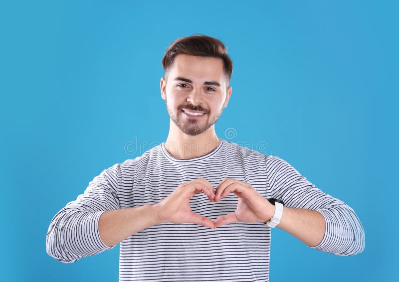 Portrait of young man making heart with his hands