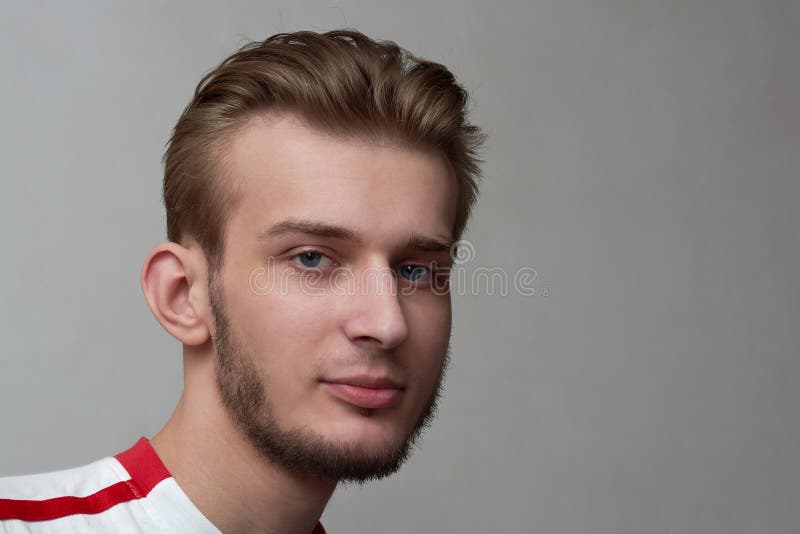 Portrait of Young Man with Slight Smile. Boy with the Beard and Stylish Haircut on the Background of Gray Wall Stock Photo - Image of person, hairstyle: 140697912 Portrait of Young Man with Slight Smile. Boy with the Beard and Stylish Haircut on the Background of Gray Wall Stock Photo - Image of person, hairstyle: 140697912
