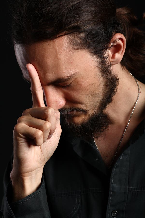 Young man points up with his index finger while touching his forehead, his eyes closed. Young man points up with his index finger while touching his forehead, his eyes closed