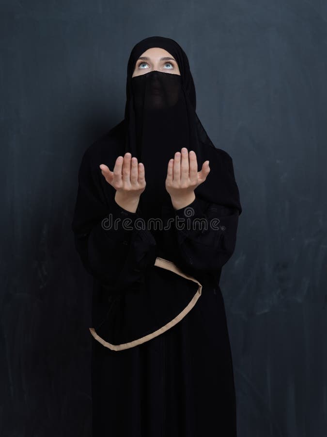 Portrait of young Muslim woman with niqab making dua