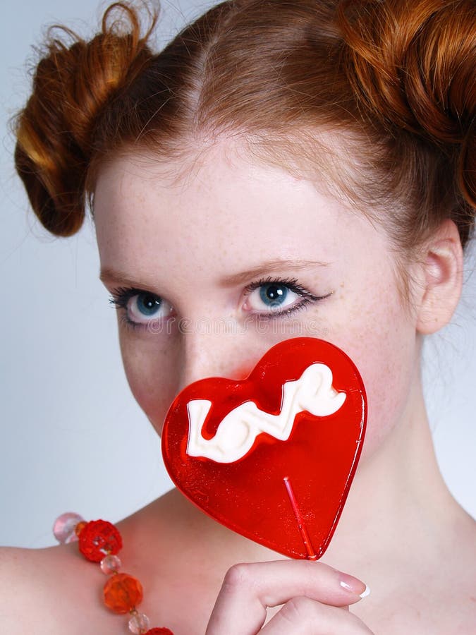 Portrait of young redheaded woman with lollipop