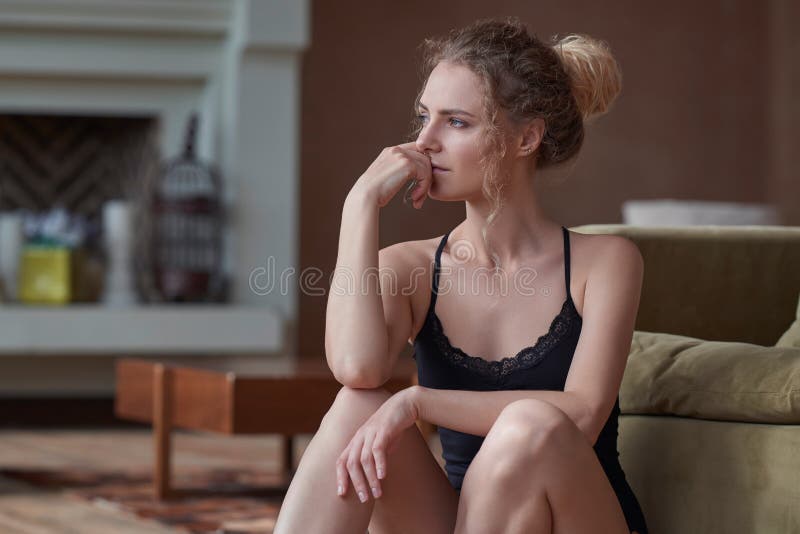 Portrait of young sad woman sitting on the floor at home