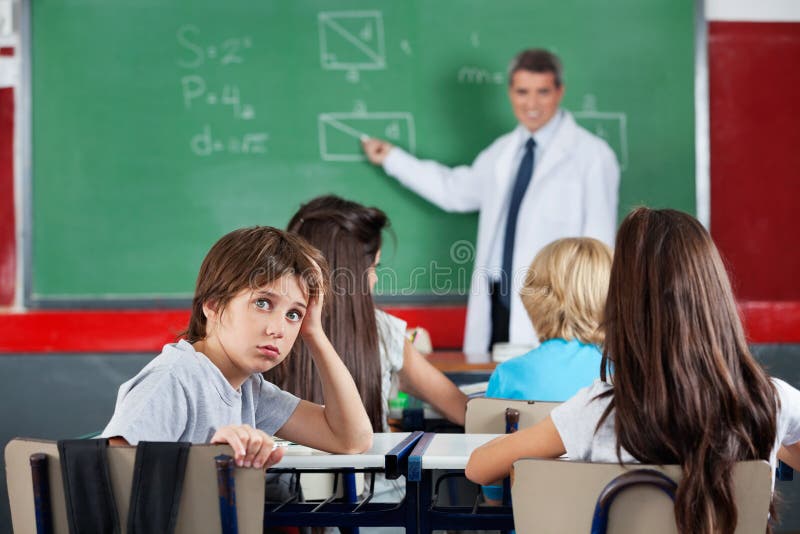 Portrait Of Young Schoolboy Leaning At Desk royalty free stock image