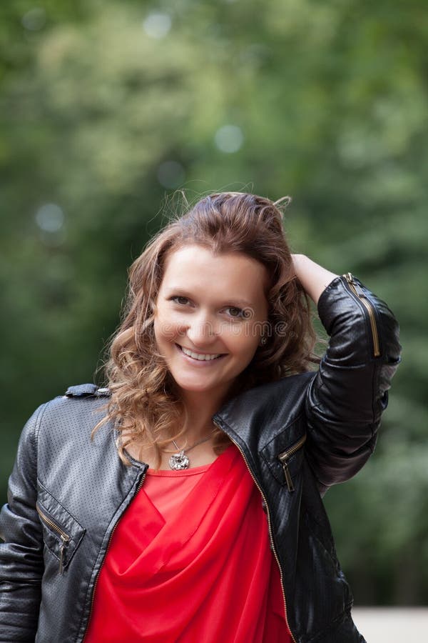 Portrait of young smiling woman in park.