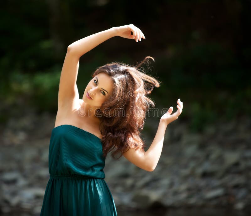 Portrait of a young woman with arms raised