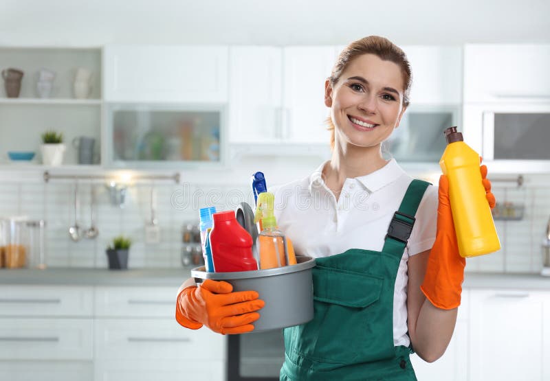 Portrait of young woman with basin of detergents and bottle in kitchen stock images Portrait of young woman with basin of detergents and bottle in kitchen stock images