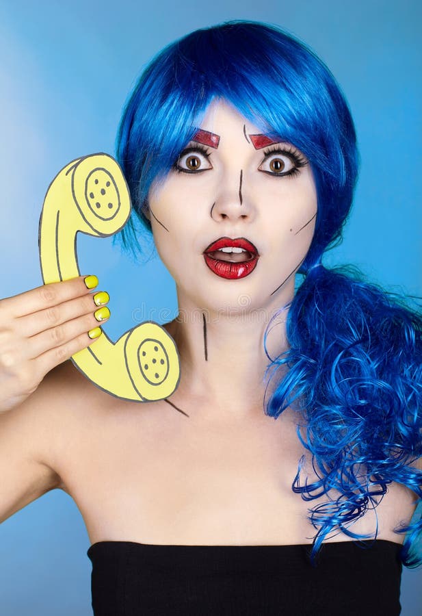Portrait of young woman in comic  pop art make-up style.  Female in blue wig on blue background calls by phone