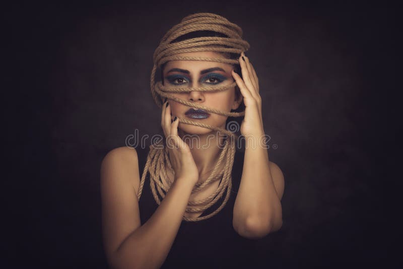 Portrait of young woman over rope with black background. Fashion, extraordinary makeup and face lifting concept. royalty free stock photography Portrait of young woman over rope with black background. Fashion, extraordinary makeup and face lifting concept. royalty free stock photography