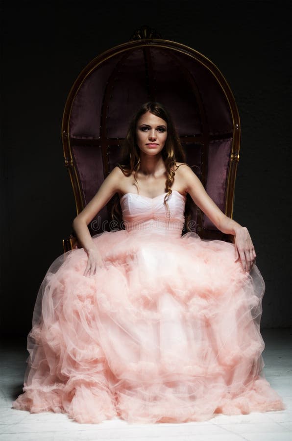 Portrait of young woman at vintage armchair