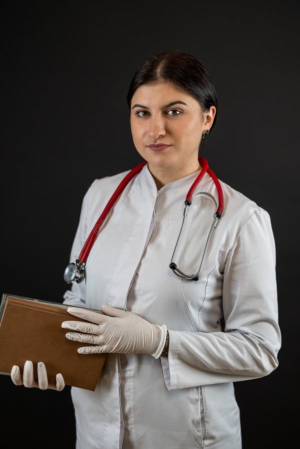 Portrait ziemlich kaukasische Krankenschwester tragen Uniform mit Stethoskop halten Zwischenwand isoliert auf schwarz stockfotografie