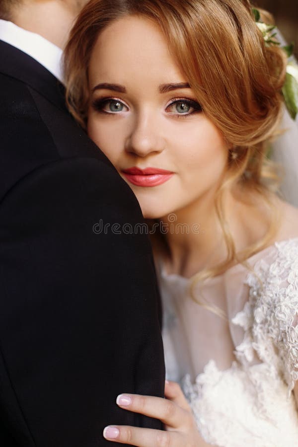 Portrait élégant de jeune mariée tandis qu'elle étreint doucement le shoulde de marié photo stock Portrait élégant de jeune mariée tandis qu'elle étreint doucement le shoulde de marié photo stock