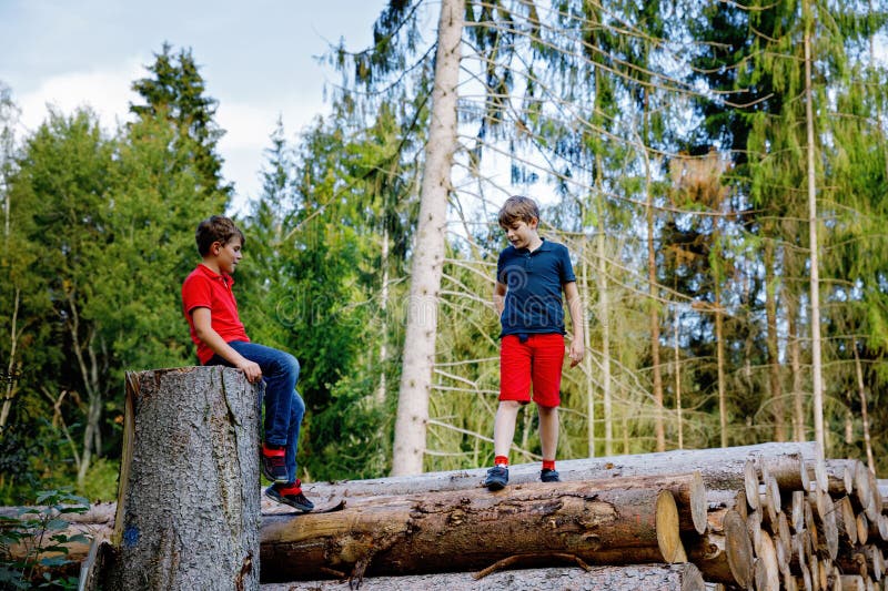 Portret al băieților din liceu care se cațără și se plimbă în pădure. Copii fericiți cei mai buni prieteni și frați distrându-se p stock photography