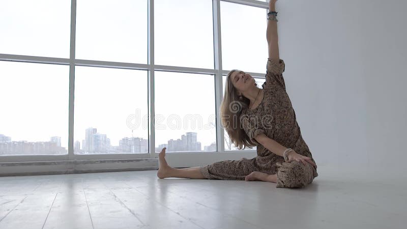Portret atrakcyjna joga kobieta ćwiczy krążącą kolano pozę