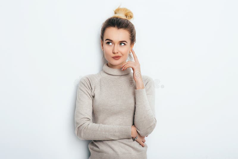 Portret atrakcyjna rozważna młoda kobieta jest ubranym jej blondynka włosy w kępki mienia forefinger w górę patrzeć daleko od z s zdjęcie stock
