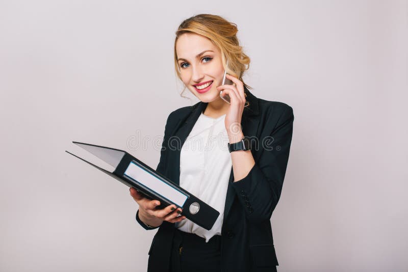 Portret blondynki radosny bizneswoman opowiada na telefonie, trzymający falcówkę, ono uśmiecha się kamera odizolowywająca na biał obraz stock Portret blondynki radosny bizneswoman opowiada na telefonie, trzymający falcówkę, ono uśmiecha się kamera odizolowywająca na biał obraz stock