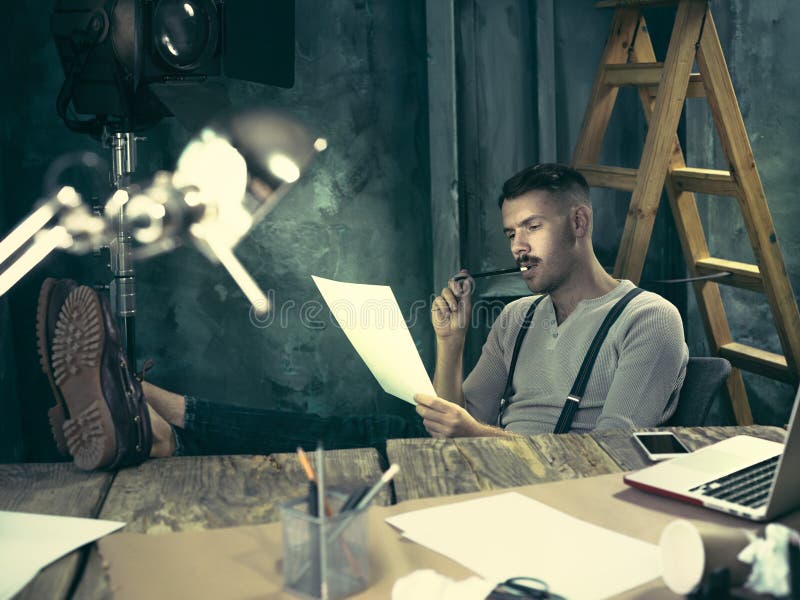 Portrait of a bearded businessman who is working with his notebook at loft studio or home. Portrait of a bearded businessman who is working with his notebook at loft studio or home.