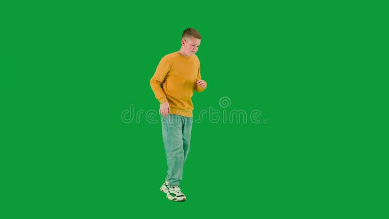 Portret chłopca na zielonym ekranie klawisza chroma. uczniak biegający i rozglądający się dookoła poważnej twarzy. pełna treść