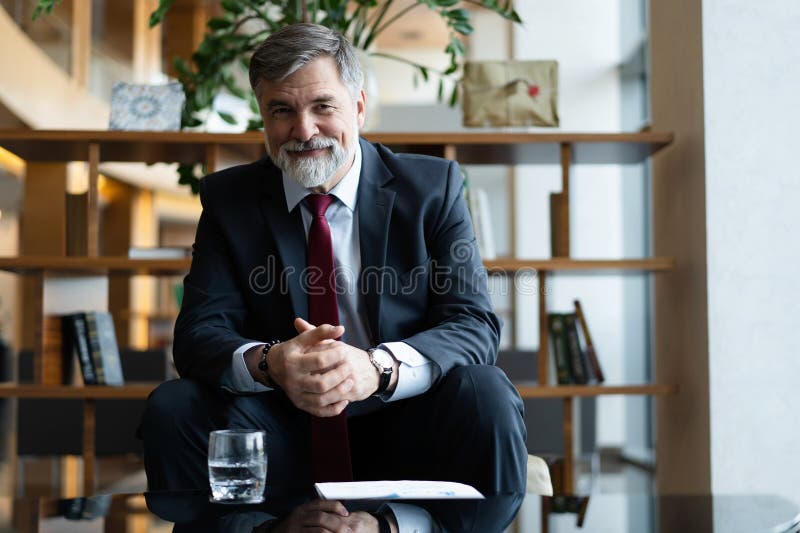 Portret de afaceri om de afaceri matur care stă în holul biroului. Bărbat care se relaxează în sala de ședințe royalty free stock photography