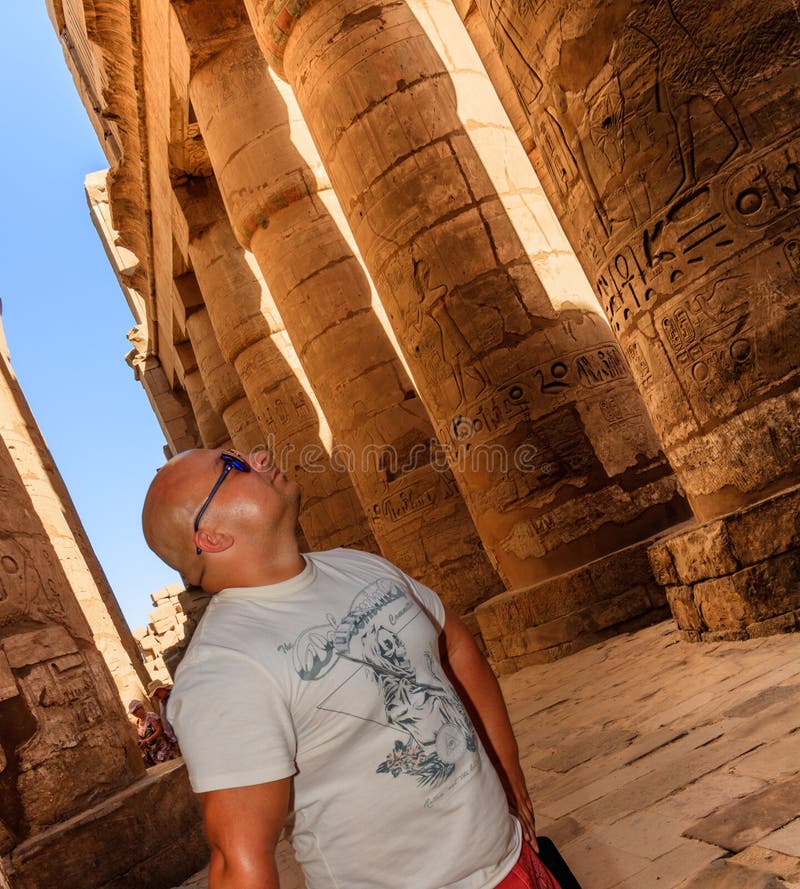 Portret de um homem que olha hieróglifos no templo de Karnak, Luxor, Egito foto de stock royalty free Portret de um homem que olha hieróglifos no templo de Karnak, Luxor, Egito foto de stock royalty free