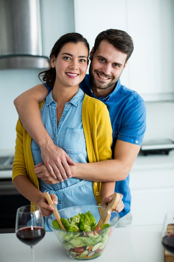 Portret die van de mens vrouw in de keuken omhelzen royalty-vrije stock afbeelding Portret die van de mens vrouw in de keuken omhelzen royalty-vrije stock afbeelding