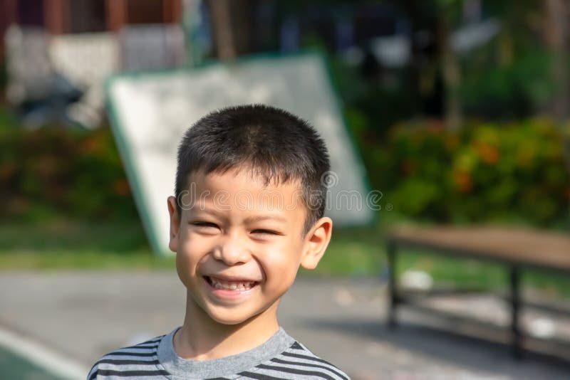 Portret die van een jongen Azië, en gelukkig in het park lachen glimlachen stock fotografie Portret die van een jongen Azië, en gelukkig in het park lachen glimlachen stock fotografie