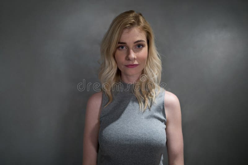 Portret die van mooie vrouw zich tegen grijze achtergrond bevinden stock foto's Portret die van mooie vrouw zich tegen grijze achtergrond bevinden stock foto's