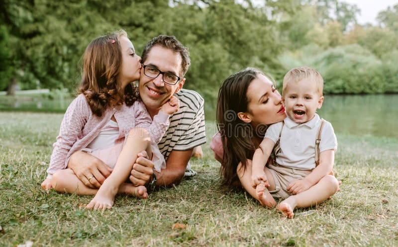Portret die van vrolijke familie in het park rusten royalty-vrije stock afbeelding Portret die van vrolijke familie in het park rusten royalty-vrije stock afbeelding