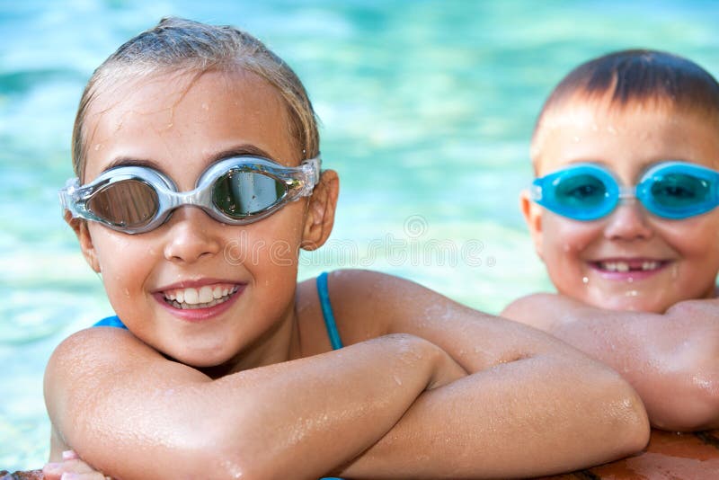 Dzieciaki w pływackim basenie z gogle.