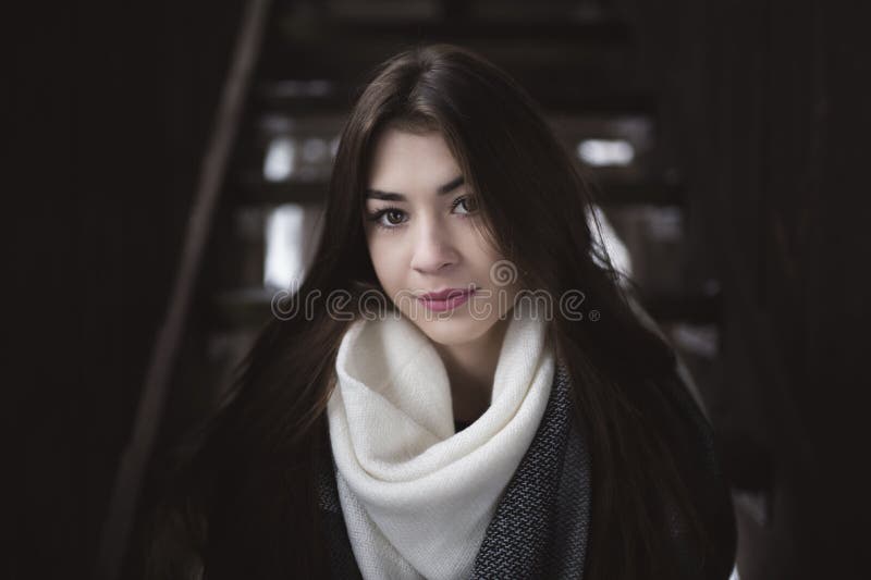 Portret dziewczyna z pięknym spojrzeniem i długie włosy Wnętrze zaniechany dom lub jata z ciemnymi drewnianymi ścianami. Portret ładna dziewczyna z pięknym spojrzeniem w kamerę i delikatna skóra i tęsk ciemny włosy Zimny zima sezon Wnętrze zaniechany dom lub jata z ciemnymi drewnianymi ścianami