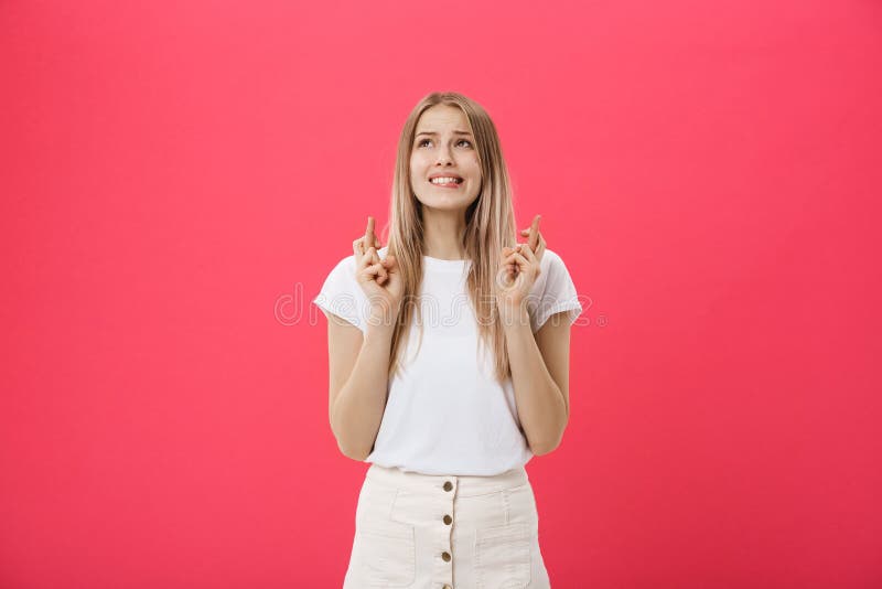 Portret dziewczyny mienia uśmiechnięci przypadkowi palce krzyżował na dobre szczęście odizolowywającego nad różowym tłem fotografia stock Portret dziewczyny mienia uśmiechnięci przypadkowi palce krzyżował na dobre szczęście odizolowywającego nad różowym tłem fotografia stock