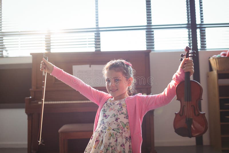 Portret dziewczyny mienia uśmiechnięty skrzypce z rękami szeroko rozpościerać