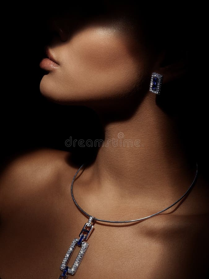 Portret elegancka i piękna potomstwo mądrze ubierająca kobieta z iskrzastą biżuterią robić od cennych metali na jej szyi