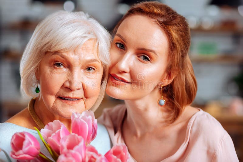 Portret fotografia ściska siwowłosych macierzystych mienie tulipany dojrzała córka obrazy stock Portret fotografia ściska siwowłosych macierzystych mienie tulipany dojrzała córka obrazy stock