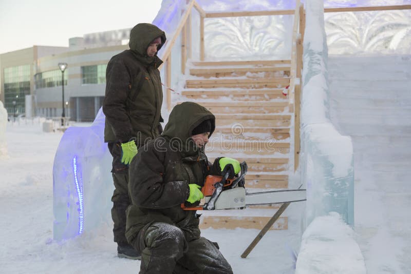 Portret instalator w pomarańczowej kamizelce z piłą łańcuchową w jego ręki fotografia stock Portret instalator w pomarańczowej kamizelce z piłą łańcuchową w jego ręki fotografia stock