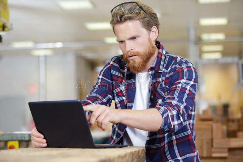 Portret jonge timmerman die laptop met behulp van stock foto Portret jonge timmerman die laptop met behulp van stock foto