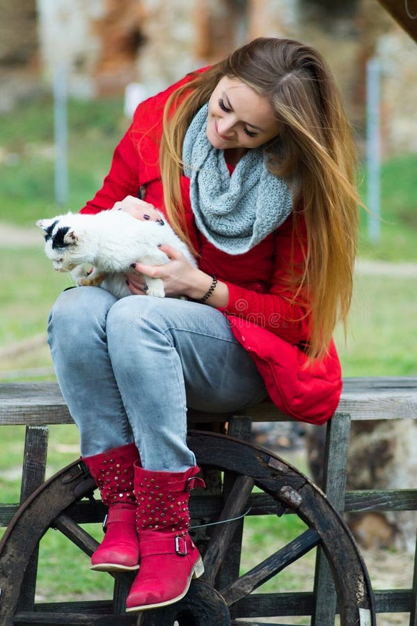 Portret kobieta ubierał w czerwieni z kotem w ona ręki zdjęcie stock Portret kobieta ubierał w czerwieni z kotem w ona ręki zdjęcie stock