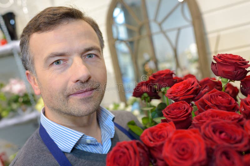 Portret kwiaciarni mienia męskie róże obrazy stock Portret kwiaciarni mienia męskie róże obrazy stock