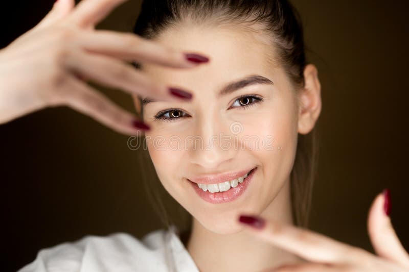 Portret m?oda pi?kna br?zowow?osa dziewczyna trzyma ona z naturalnym makeup palce przed ona twarz zdjęcia stock Portret m?oda pi?kna br?zowow?osa dziewczyna trzyma ona z naturalnym makeup palce przed ona twarz zdjęcia stock
