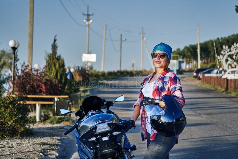 Portret miedzianow?osa w ?rednim wieku kobieta po motocykl przeja?d?ki na pogodnym wiecz?r w wiecz?r zdjęcia royalty free Portret miedzianow?osa w ?rednim wieku kobieta po motocykl przeja?d?ki na pogodnym wiecz?r w wiecz?r zdjęcia royalty free