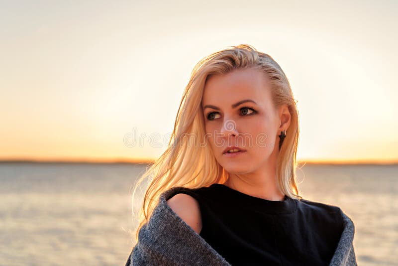 Portret młoda blond kobieta z zmierzchem na tle i światłem słonecznym w jej włosy obrazy royalty free Portret młoda blond kobieta z zmierzchem na tle i światłem słonecznym w jej włosy obrazy royalty free