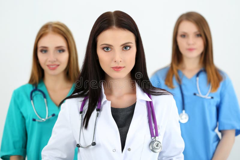 Portret młoda brunetki kobiety lekarka otaczająca zaopatrzeniem medycznym zdjęcia stock Portret młoda brunetki kobiety lekarka otaczająca zaopatrzeniem medycznym zdjęcia stock