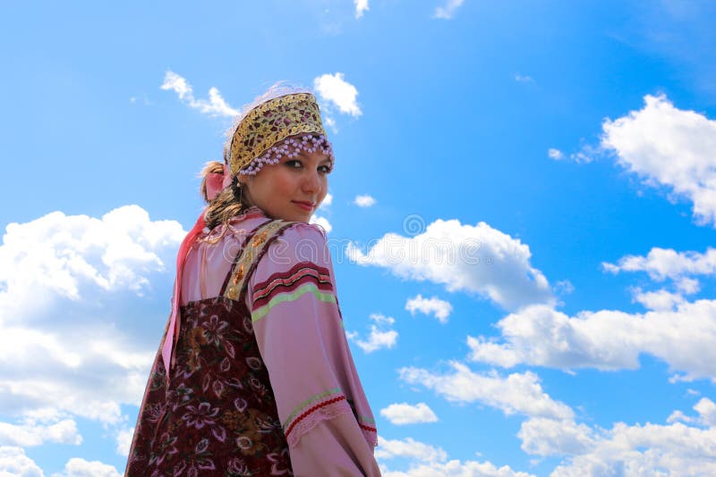 Portret młoda dziewczyna w Rosyjskim ludowym kostiumu na nieba tle fotografia stock Portret młoda dziewczyna w Rosyjskim ludowym kostiumu na nieba tle fotografia stock