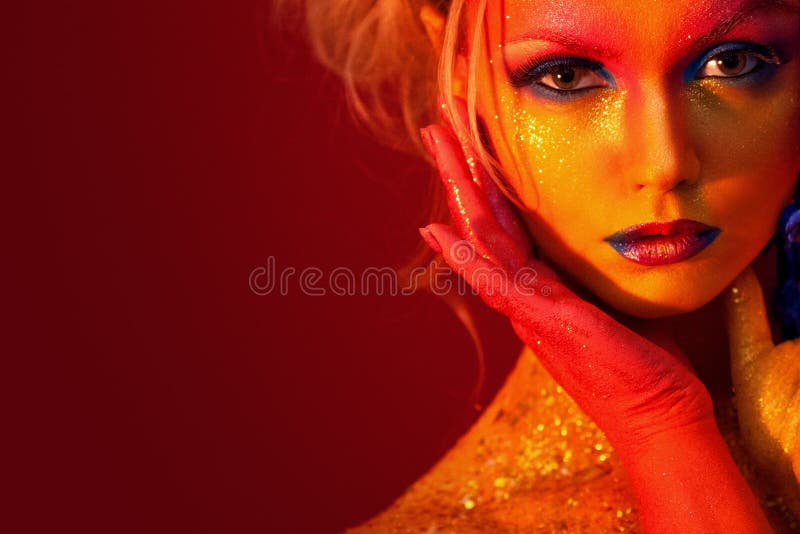Portret młoda i atrakcyjna kobieta z sztuki makeup Ogniści kolory, błyskotliwość na twarzy i kwiecista dekoracja