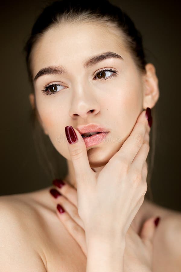 Portret młoda powabna dziewczyna trzyma jej ręki na ona z naturalnym makeup twarz zdjęcie stock Portret młoda powabna dziewczyna trzyma jej ręki na ona z naturalnym makeup twarz zdjęcie stock