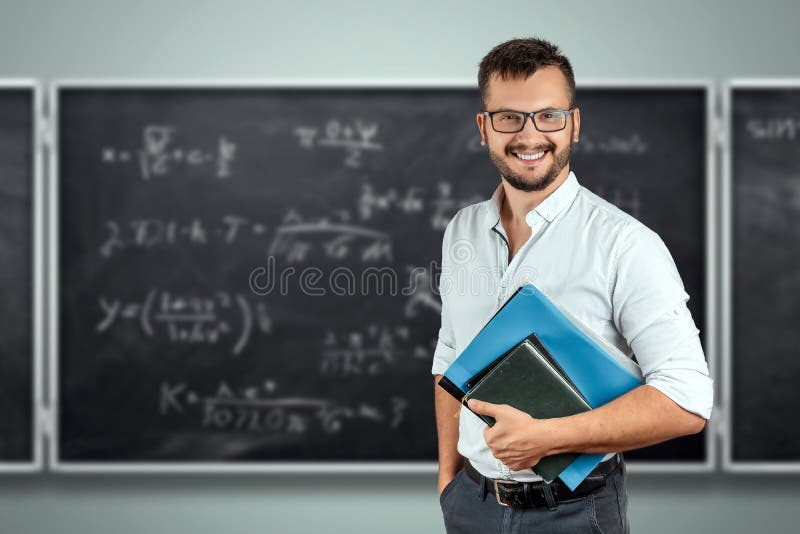 Portret młodego nauczyciela płci męskiej w tle tablicy szkolnej Dzień Wiedzy Nauczyciela - powrót do szkoły fotografia stock Portret młodego nauczyciela płci męskiej w tle tablicy szkolnej Dzień Wiedzy Nauczyciela - powrót do szkoły fotografia stock