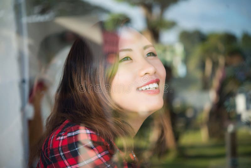 Portret młodego pięknego modnisia uśmiechnięta kobieta blisko windo fotografia stock Portret młodego pięknego modnisia uśmiechnięta kobieta blisko windo fotografia stock