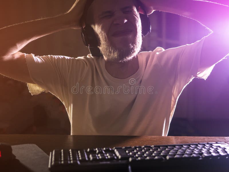 Portret młody brodaty męski gamer bawić się wideo grę w nocy iść szalenie szalonym zdjęcie royalty free Portret młody brodaty męski gamer bawić się wideo grę w nocy iść szalenie szalonym zdjęcie royalty free